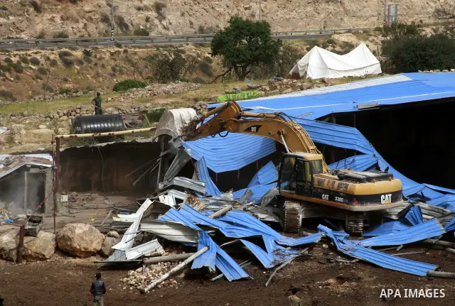 Israeli soldiers surround a bulldozer as it destroys a Palestinian farm to cows in the West Bank city of Hebron, May. 01, 2012. Reports state that tensions rose as Palestinian homes were destroyed by Israeli authorities...