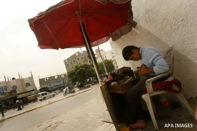 A Palestinian boy repairs shoes in one of the streets to mark "workers' Day" in Rafah town In Gaza Strip, on May 01, 2012. Photo by Eyad Al Baba