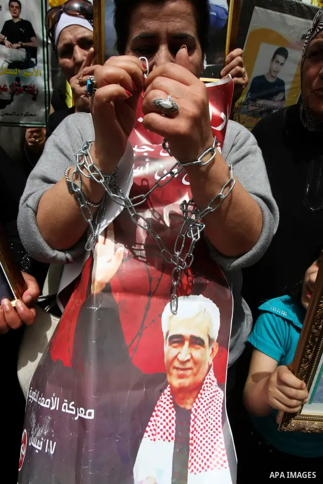 Palestinian protesters hold up banners and portraits of a prisoners jailed in Israel, during a demonstration in the West Bank city of Nablus, May 1, 2012. Over the past week, over 1,350 Palestinian prisoners have begun a...