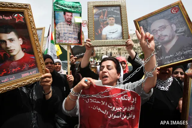 Palestinian protesters hold up banners and portraits of a prisoners jailed in Israel, during a demonstration in the West Bank city of Nablus, May 1, 2012. Over the past week, over 1,350 Palestinian prisoners have begun a...