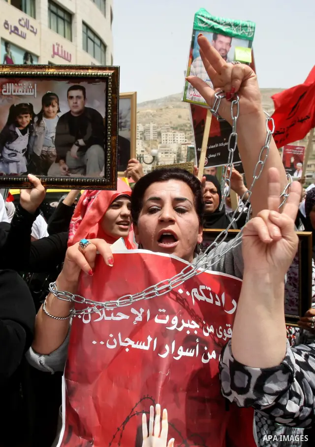 Palestinian protesters hold up banners and portraits of a prisoners jailed in Israel, during a demonstration in the West Bank city of Nablus, May 1, 2012. Over the past week, over 1,350 Palestinian prisoners have begun a...