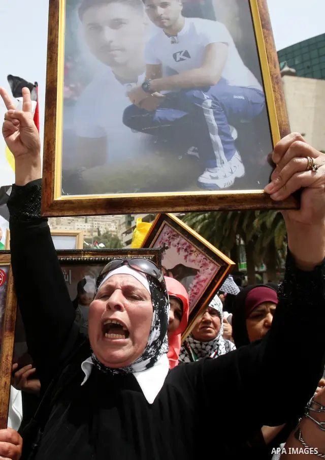 Palestinian protesters hold up banners and portraits of a prisoners jailed in Israel, during a demonstration in the West Bank city of Nablus, May 1, 2012. Over the past week, over 1,350 Palestinian prisoners have begun a...
