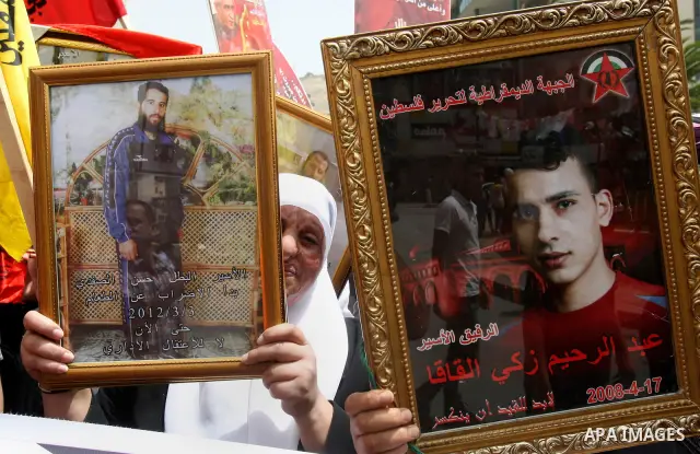 Palestinian protesters hold up banners and portraits of a prisoners jailed in Israel, during a demonstration in the West Bank city of Nablus, May 1, 2012. Over the past week, over 1,350 Palestinian prisoners have begun a...