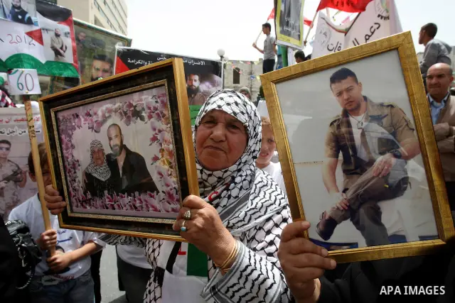 Palestinian protesters hold up banners and portraits of a prisoners jailed in Israel, during a demonstration in the West Bank city of Nablus, May 1, 2012. Over the past week, over 1,350 Palestinian prisoners have begun a...