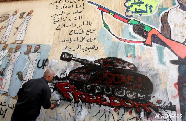 Egyptian artist puts the final touches to graffiti on a wall in Tahrir Square in Cairo on May 01, 2012. Egyptians demanded that their military rulers pledge to hand over power by mid-year after a row over who can run in...