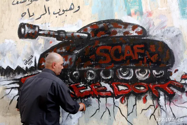 Egyptian artist puts the final touches to graffiti on a wall in Tahrir Square in Cairo on May 01, 2012. Egyptians demanded that their military rulers pledge to hand over power by mid-year after a row over who can run in...