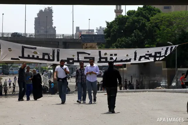 Egyptians walk near the Ministry of Defense in the Abbassiya district of Cairo on May 01, 2012. Protesters demanded that their military rulers pledge to hand over power by mid-year after a row over who can run in the pre...