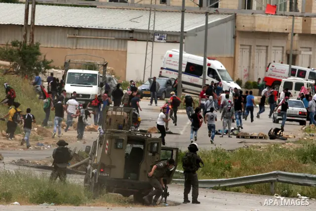 Palestinian protesters throw stones at Israeli troops during a demonstration outside Ofer military prison near the West Bank city of Ramallah on May 1, 2012 in a show of support for prisoners held in Israeli jails. Clash...