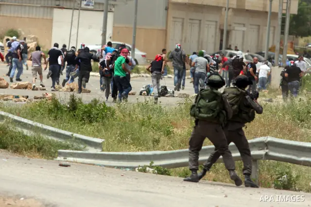 Palestinian protesters throw stones at Israeli troops during a demonstration outside Ofer military prison near the West Bank city of Ramallah on May 1, 2012 in a show of support for prisoners held in Israeli jails. Clash...