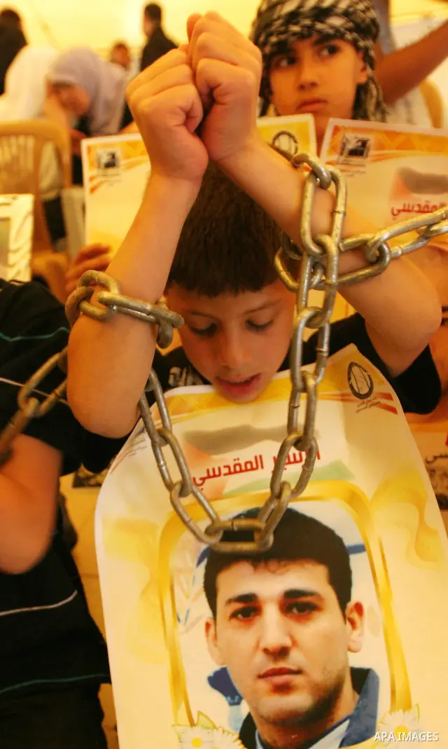 Palestinian child holds up banners and portraits of a prisoners jailed in Israel, during a Sit-in held in the West Bank city of Jerusalem, May 01, 2012. Over the past week, over 1,350 Palestinian prisoners have begun an...