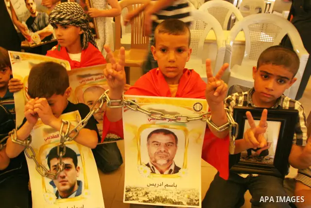 Palestinian children hold up banners and portraits of a prisoners jailed in Israel, during a Sit-in held in the West Bank city of Jerusalem, May 01, 2012. Over the past week, over 1,350 Palestinian prisoners have begun a...