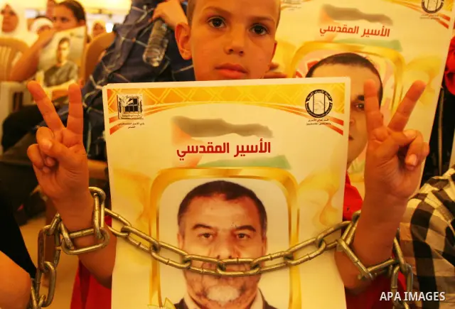 Palestinian child hold up banners and portraits of a prisoners jailed in Israel, during a Sit-in held in the West Bank city of Jerusalem, May 01, 2012. Over the past week, over 1,350 Palestinian prisoners have begun an o...