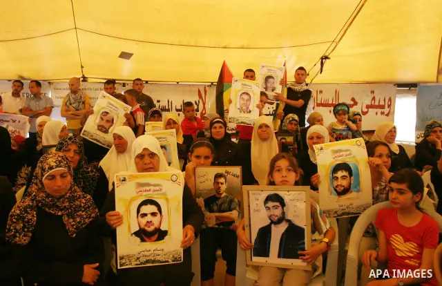 Palestinian protesters hold up banners and portraits of a prisoners jailed in Israel, during a Sit-in held in the West Bank city of Jerusalem, May 01, 2012. Over the past week, over 1,350 Palestinian prisoners have begun...