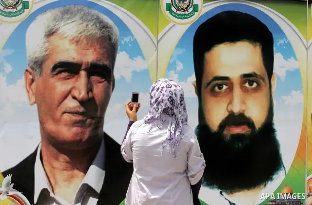 A Palestinian girl looks at posters of Palestinian prisoners, during a rally held by hunger striking activists in solidarity with Palestinians prisoners held in Israeli jails, in Gaza City, Wednesday, May 2, 2012. A Pale...