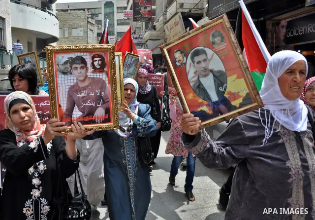 Palestinian protesters hold up banners and portraits of a prisoners jailed in Israel, during a rally in solidarity with prisoners in Israeli jails, in the West Bank city of Nablus on May 2, 2012. Photo by Nedal Eshtayah