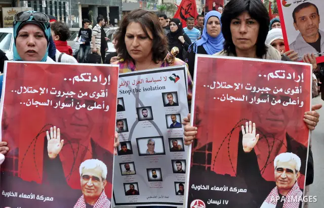 Palestinian protesters hold up banners and portraits of a prisoners jailed in Israel, during a rally in solidarity with prisoners in Israeli jails, in the West Bank city of Nablus on May 2, 2012. Photo by Nedal Eshtayah