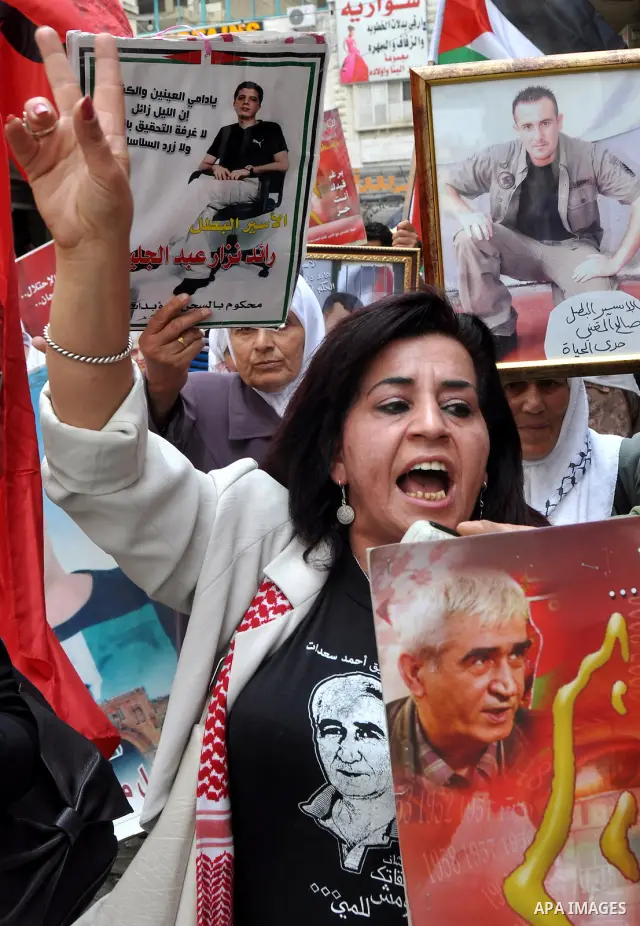 Palestinian protesters hold up banners and portraits of a prisoners jailed in Israel, during a rally in solidarity with prisoners in Israeli jails, in the West Bank city of Nablus on May 2, 2012. Photo by Nedal Eshtayah