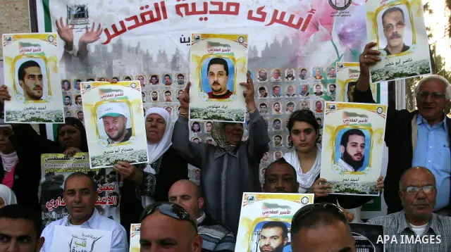Palestinian protesters hold up banners and portraits of a prisoners jailed in Israel, during a Sit-in held outside the International Committee of the Red Cross (ICRC) in the West Bank, city of Jerusalem, May 02, 2012. Ov...