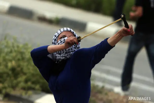 A Palestinian girl throw stones at Israeli soldiers during clashes next to the Israeli military prison of Ofer, near Beitunia, West Bank, 02 May 2012. The protesters were protesting in solidarity with the Palestinian pri...