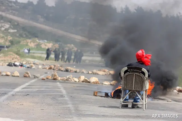 A Palestinian protester sets on a chair in front of Israeli troops during clashes next to the Israeli military prison of Ofer, near Beitunia, West Bank, 02 May 2012. The protesters were protesting in solidarity with the...