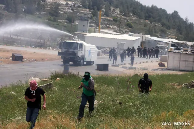 A Palestinian protester runs away from spraying foul smelling water fired by Israeli forces during clashes next to the Israeli military prison of Ofer, near Beitunia, West Bank, 02 May 2012. The protesters were protestin...
