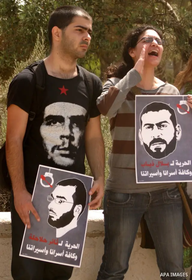 Palestinians and Israeli Arab protesters hold posters depicting Palestinian hunger strikers Thaer Halahla and Bilal Thiab (R) who are in administrative detention during a protest outside Israel's Supreme Court in Jerusal...