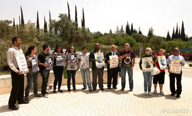 Palestinians and Israeli Arab protesters hold posters depicting Palestinian hunger strikers Thaer Halahla and Bilal Thiab (R) who are in administrative detention during a protest outside Israel's Supreme Court in Jerusal...