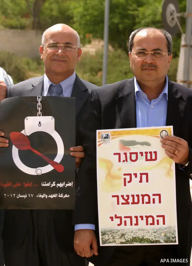 Palestinians and Israeli Arab protesters hold posters depicting Palestinian hunger strikers Thaer Halahla and Bilal Thiab (R) who are in administrative detention during a protest outside Israel's Supreme Court in Jerusal...