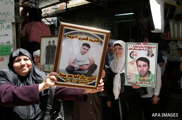 Palestinian protesters hold up pictures and portraits of a prisoners jailed in Israel, during a rally in solidarity with prisoners in Israeli jails, in the West Bank city of Nablus, 03 May, 2012. Over 1,350 Palestinian p...