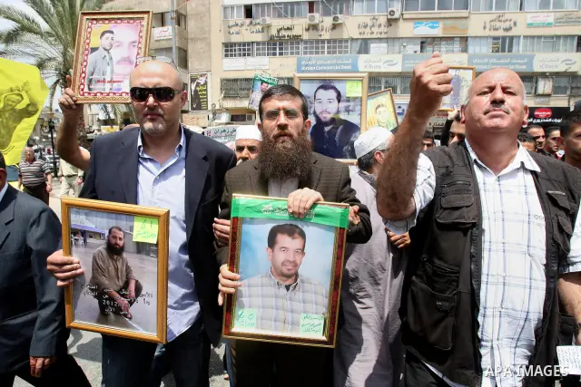 Palestinian protesters hold up pictures and portraits of a prisoners jailed in Israel, during a rally in solidarity with prisoners in Israeli jails, in the West Bank city of Nablus, 03 May, 2012. Over 1,350 Palestinian p...