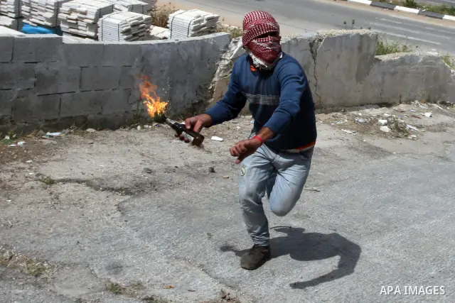 A Palestinian protester throws a molotov towards Israeli troops during clashes next to the Israeli military prison of Ofer, near Beitunia, West Bank, 03 May 2012. following a demonstration in solidarity with Palestinian...