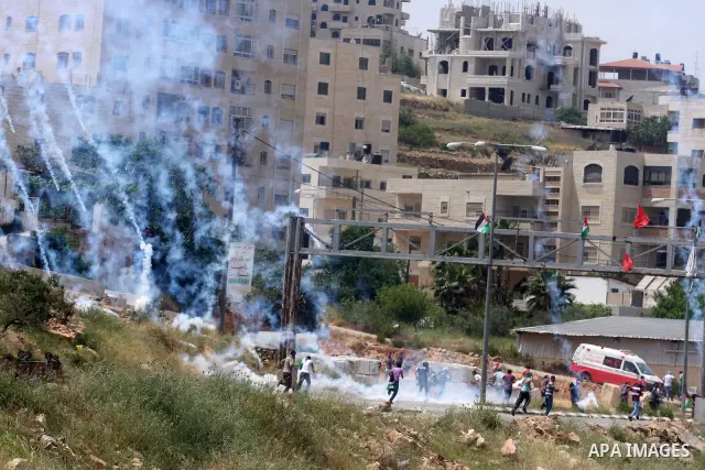 Tear gas fired by Israeli troops falls near Palestinian stone-throwers during clashes next to the Israeli military prison of Ofer, near Beitunia, West Bank, 03 May 2012. following a demonstration in solidarity with Pales...