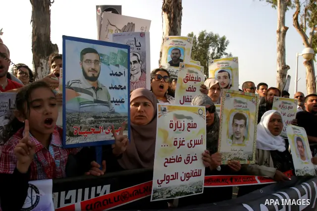 Palestinian protesters hold up banners and portraits of a prisoners jailed in Israel, during a rally next to Al-Ramle Prison, near Tel Aviv, Thursday, May 3, 2012. A Palestinian rights group said recently that half of ab...