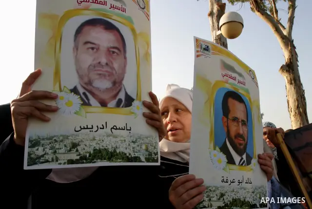 Palestinian protesters hold up banners and portraits of a prisoners jailed in Israel, during a rally next to Al-Ramle Prison, near Tel Aviv, Thursday, May 3, 2012. A Palestinian rights group said recently that half of ab...