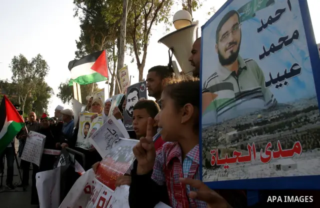 Palestinian protesters hold up banners and portraits of a prisoners jailed in Israel, during a rally next to Al-Ramle Prison, near Tel Aviv, Thursday, May 3, 2012. A Palestinian rights group said recently that half of ab...