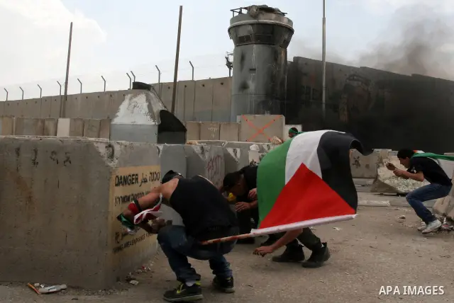 Palestinian men throw stones at Israeli soldiers at the Qalandia crossing in the occupied West Bank during a demonstration on May 4, 2012 in solidarity with Palestinian prisoners on hunger strike to protest Israel's use...