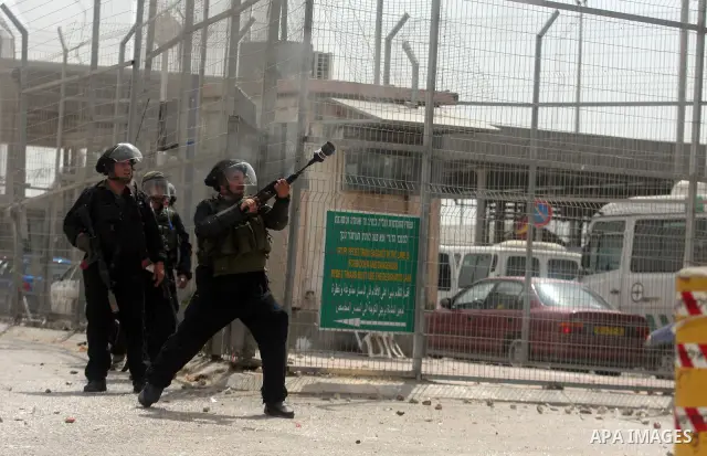 Israeli troops fire tear gas and rubber bullets towards Palestinian stone-throwers during clashes with Palestinian stone-throwers in Qalandia in the occupied West Bank, following a demonstration on May 4, 2012 solidarity...