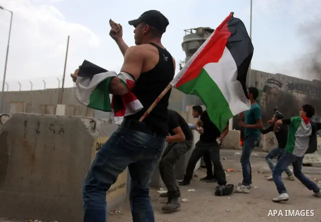 Palestinian men throw stones at Israeli soldiers at the Qalandia crossing in the occupied West Bank during a demonstration on May 4, 2012 in solidarity with Palestinian prisoners on hunger strike to protest Israel's use...