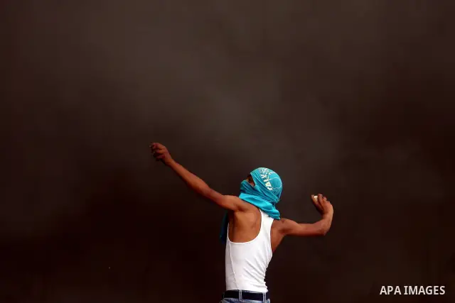 A Palestinian man throws stones at Israeli soldiers at the Qalandia crossing in the occupied West Bank during a demonstration on May 4, 2012 in solidarity with Palestinian prisoners on hunger strike to protest Israel's u...
