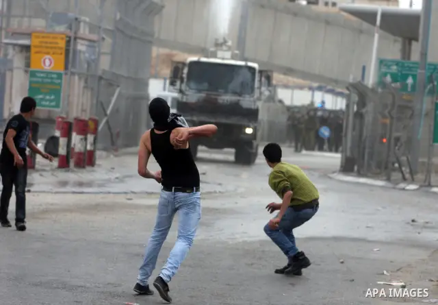 Palestinian men throw stones at Israeli soldiers at the Qalandia crossing in the occupied West Bank during a demonstration on May 4, 2012 in solidarity with Palestinian prisoners on hunger strike to protest Israel's use...