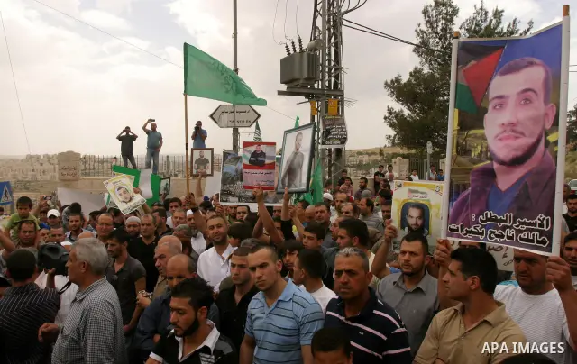 Palestinian protesters hold up banners and portraits of a prisoners jailed in Israel, during a Sit-in held in old City of Jerusalem, May 04, 2012. Over the past week, over 1400 Palestinian prisoners have begun an open-en...