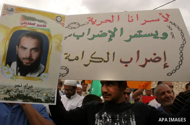 Palestinian protesters hold up banners and portraits of a prisoners jailed in Israel, during a Sit-in held in old City of Jerusalem, May 04, 2012. Over the past week, over 1400 Palestinian prisoners have begun an open-en...