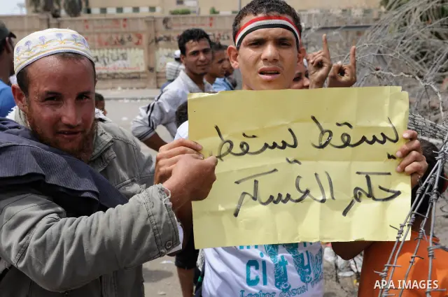 May 4, 2012 - Cairo, Egypt - Egyptians protest during the 'Final Friday' march against Military Rule in the Abasseya neighborhood of Cairo on May 4, 2012. The sign reads, ''Down Down with Government of the Military.'' Th...