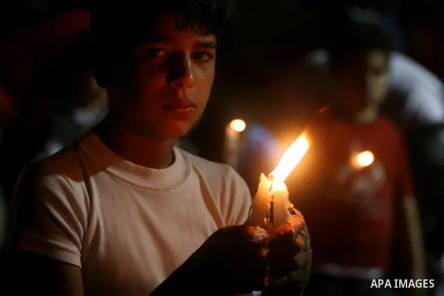Palestinian children light candles, during a rally outside a tent solidarity with prisoners who have been waging a hunger strike in Israeli jails, to protest Israel's use of administrative detention orders, in the West B...