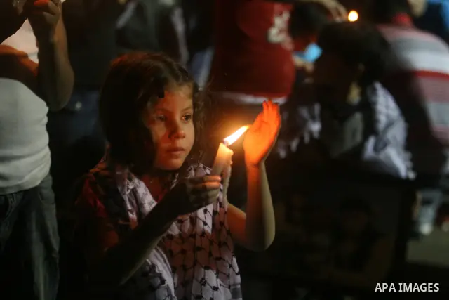 Palestinian children light candles, during a rally outside a tent solidarity with prisoners who have been waging a hunger strike in Israeli jails, to protest Israel's use of administrative detention orders, in the West B...