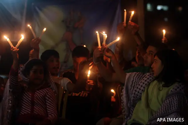 Palestinian children light candles, during a rally outside a tent solidarity with prisoners who have been waging a hunger strike in Israeli jails, to protest Israel's use of administrative detention orders, in the West B...