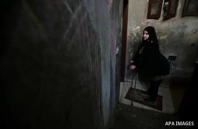Jamela Al-Habash, a 17-year-old Palestinian girl who lost her legs, uses a pair of crutches to help her to walk with her artificial limbs before leaving her family's home in the Jabaliya refugee camp in the Gaza Strip, 0...