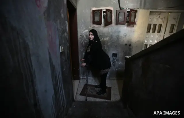 Jamela Al-Habash, a 17-year-old Palestinian girl who lost her legs, uses a pair of crutches to help her to walk with her artificial limbs before leaving her family's home in the Jabaliya refugee camp in the Gaza Strip, 0...