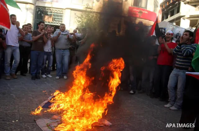 Palestinians burn Israeli flags during a support rally for Palestinian prisoners on hunger strike, in the West Bank city of Ramallah, May 6, 2012. Photo by Issam Rimawi