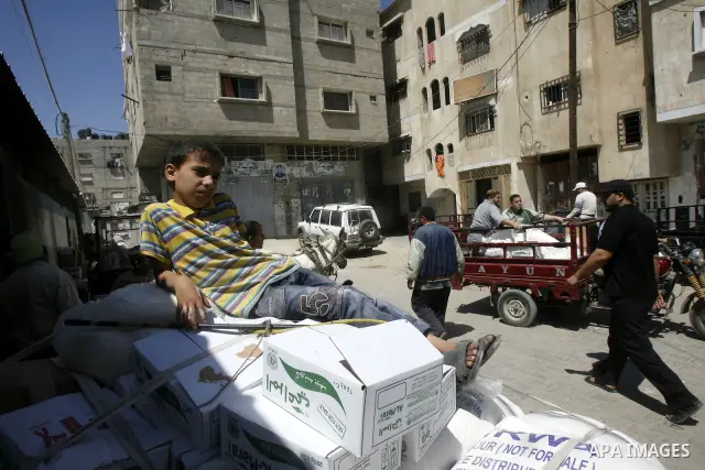 A Palestinian boy receives monthly food aid from the United Nations Relief and Works Agency (UNRWA) center in the Rafah refugee camp, southern Gaza on May 07, 2012. The UN Agency for Palestinian Refugees (UNRWA) in Gaza...